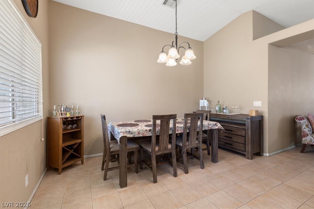 2377 Ramsgate Drive Henderson, NV 89074 - Photo 12 of 25 High ceilings elevate this dining area, featuring practical tiled flooring and a classic chandelier.