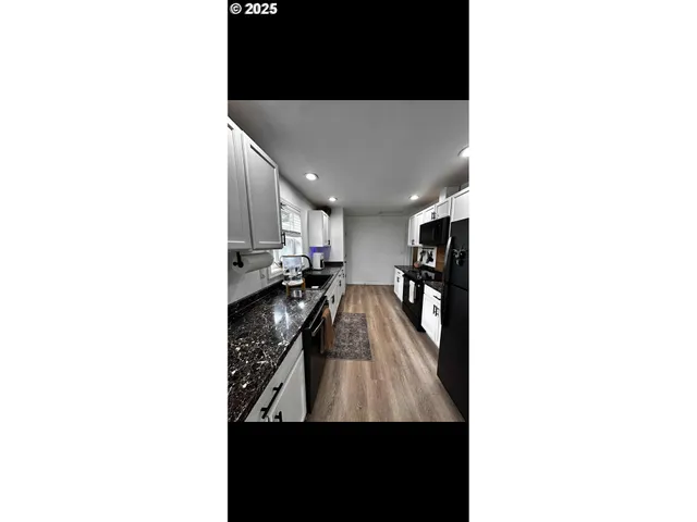 a view of a living room with kitchen area