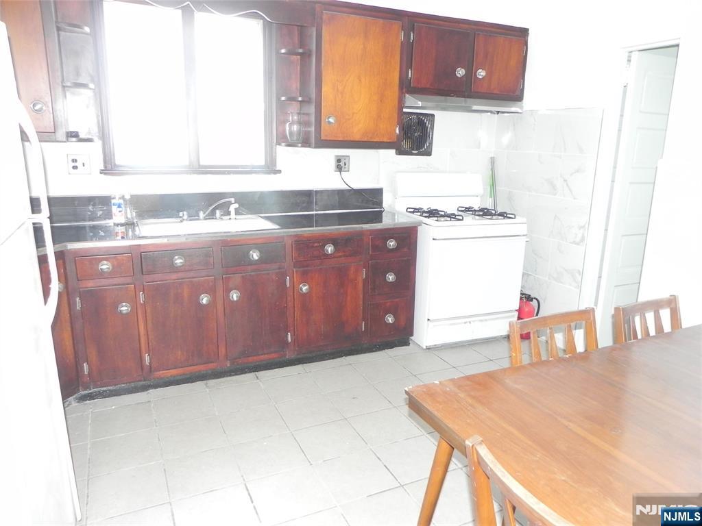 33 Center Street, Unit 1 Little Ferry, NJ 07643 - Photo 5 of 12 a kitchen with a sink a stove and a wooden cabinets