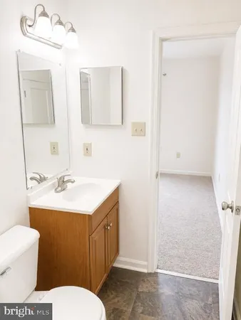 a bathroom with a toilet a sink and a mirror