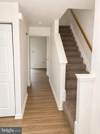 a view of a hallway with wooden floor and stairs