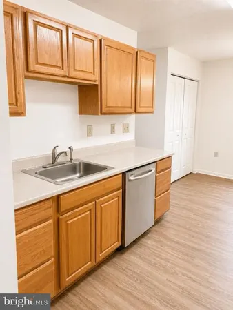 a kitchen with stainless steel appliances granite countertop a sink cabinets and wooden floor