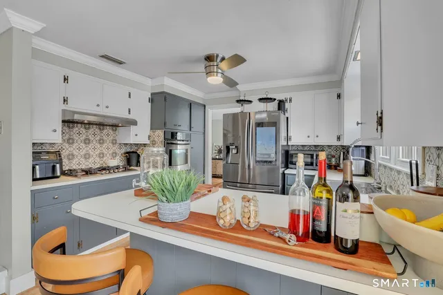 a kitchen with stainless steel appliances granite countertop a dining table and chairs