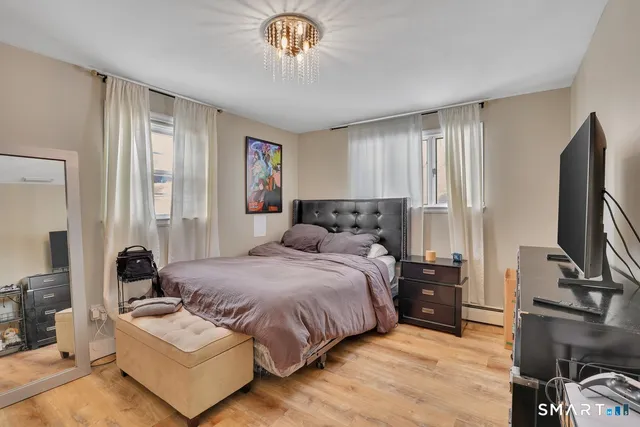 a bedroom with double bed windows and a flat screen tv