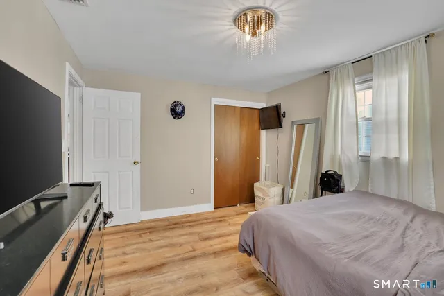 a bedroom with a bed and a flat tv screen on dresser
