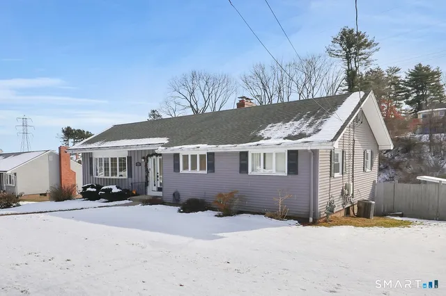 a front view of a house with a yard covered with snow