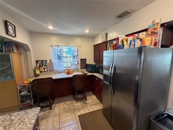 a living room with furniture a refrigerator and a window