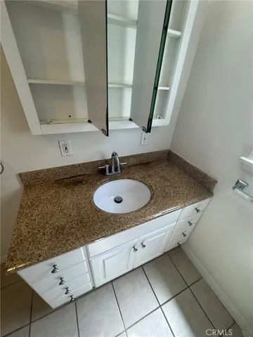 a bathroom with a granite countertop sink and a mirror