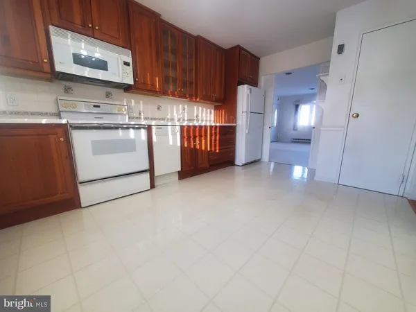 a view of kitchen with cabinets and white appliances