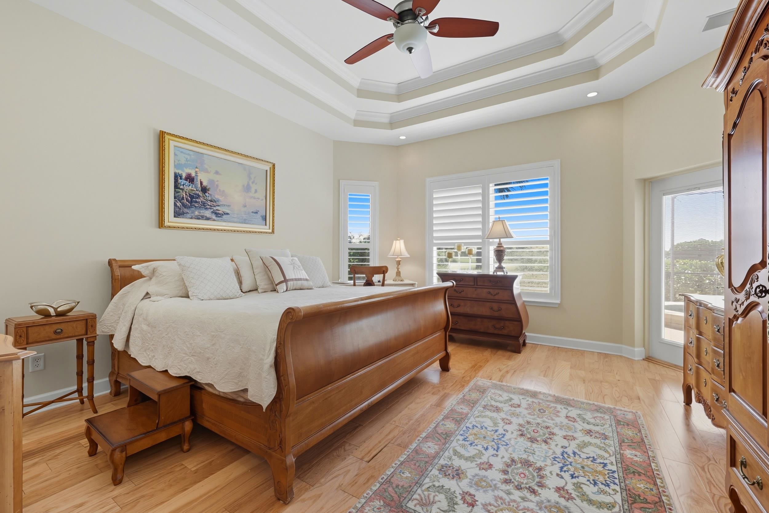 305 Marsh Point Circle St. Augustine, FL 32080 - Photo 23 of 82 Bedroom featuring a tray ceiling, light wood-style floors, ornamental molding, and a ceiling fan