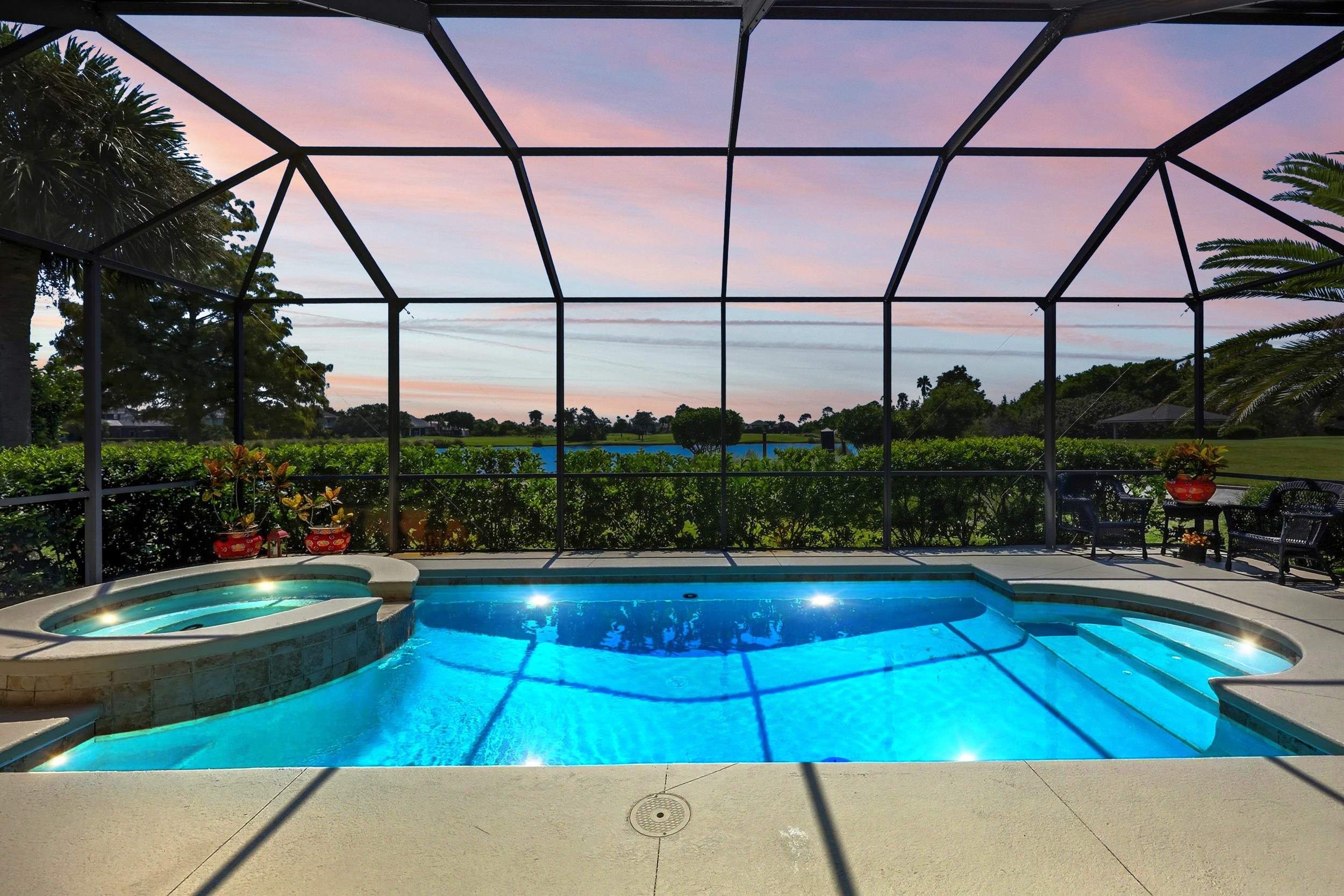 305 Marsh Point Circle St. Augustine, FL 32080 - Photo 62 of 82 Pool at dusk featuring a sunroom, a pool with connected hot tub, and glass enclosure