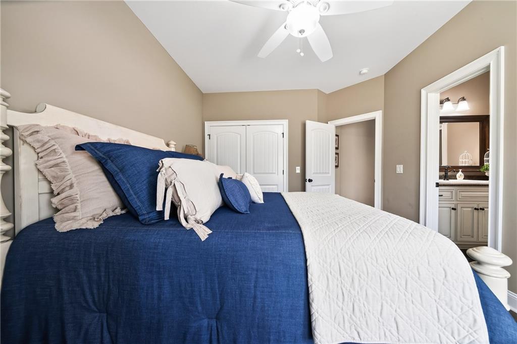 611 Padgetts Road Opelika, AL 36804 - Photo 38 of 64 Vaulted ceiling, white ceiling fan, warm neutral wall tones, double-door closet, and an attached bathroom with vanity