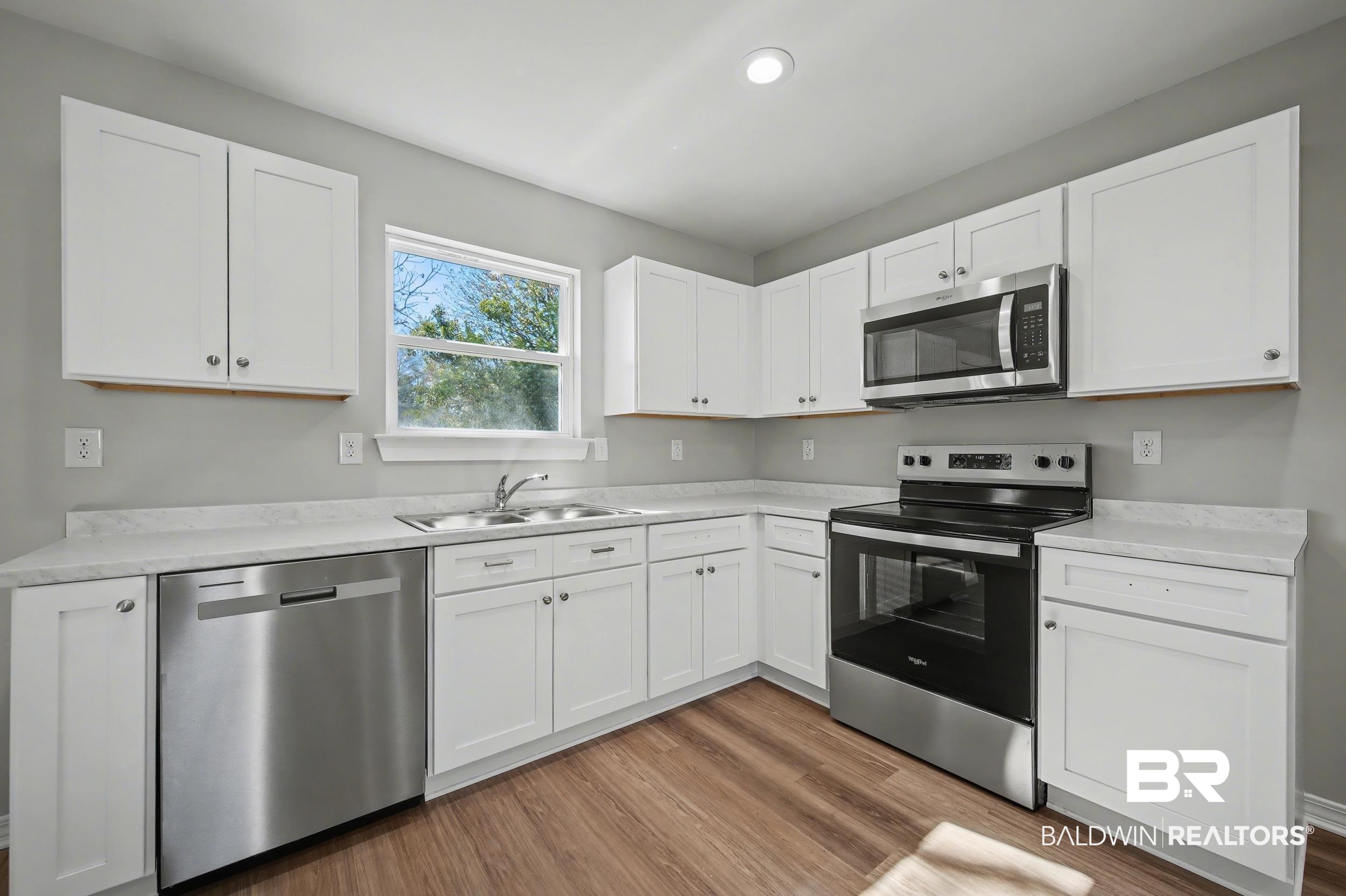 76 Fincher Lane Loxley, AL 36551 - Photo 11 of 33 Kitchen featuring stainless steel appliances, white cabinetry, light countertops, and light wood-style floors