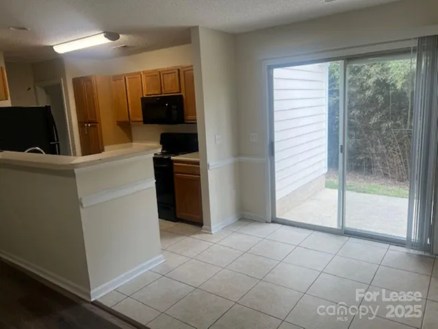 a view of a kitchen with microwave and refrigerator