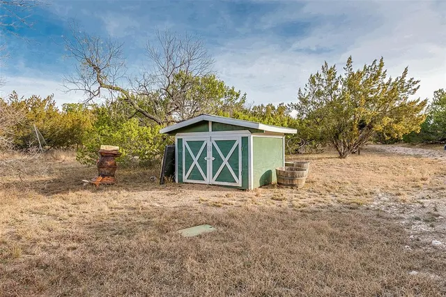 a view of a backyard with wooden fence and large windows