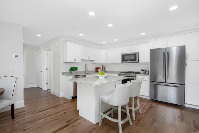 a kitchen with white cabinets and stainless steel appliances