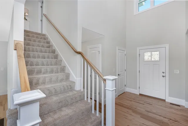 a view of front door with wooden floor and stairs