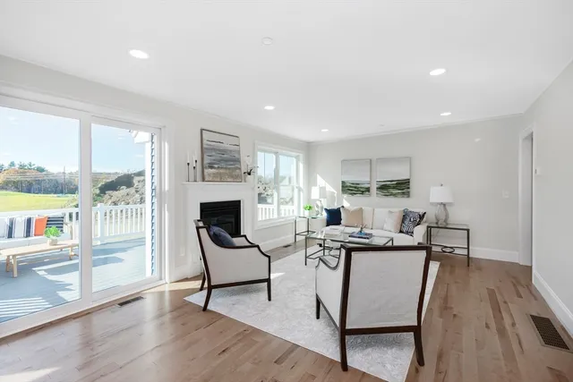 a living room with furniture a fireplace and a floor to ceiling window