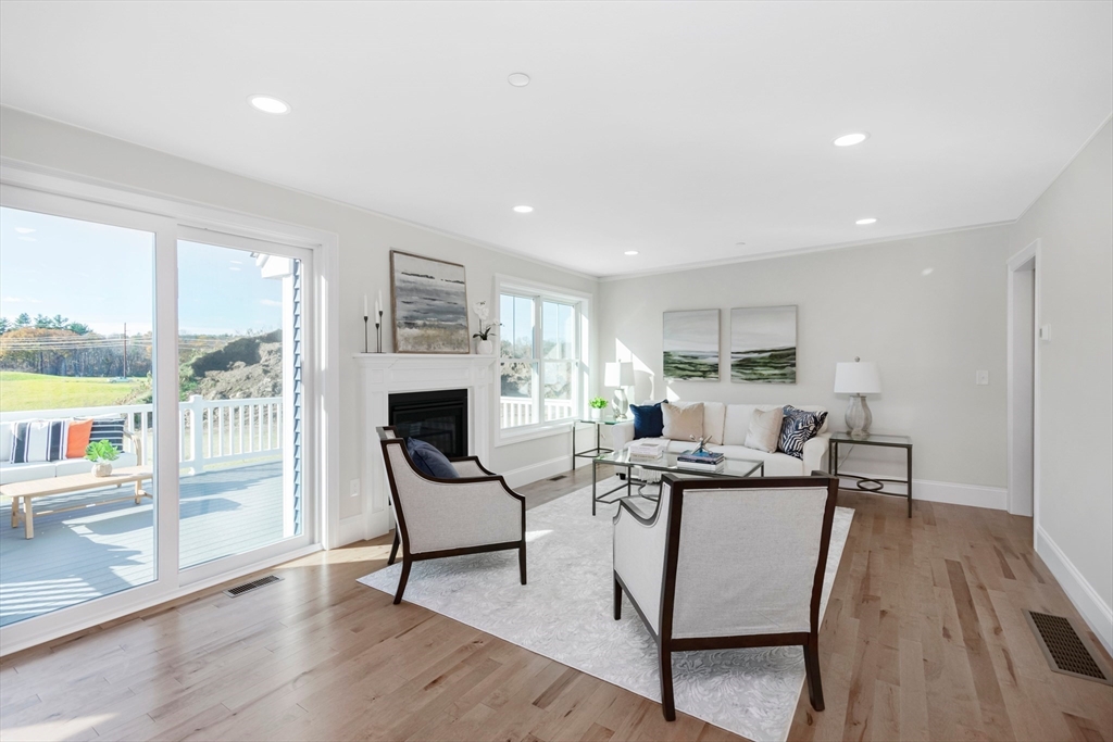 150 County Amherst, NH 03031 - Photo 6 of 26 a living room with furniture a fireplace and a floor to ceiling window