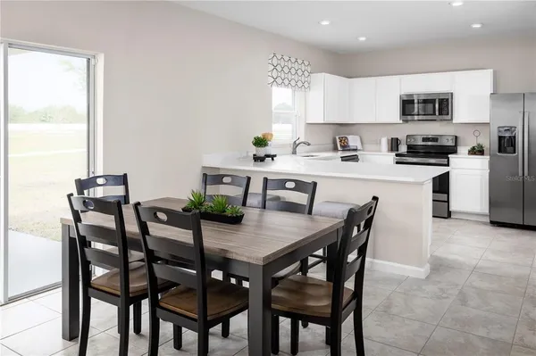 a kitchen with kitchen island a dining table and chairs
