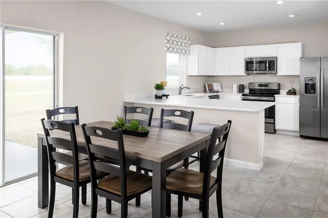 a kitchen with kitchen island a dining table and chairs