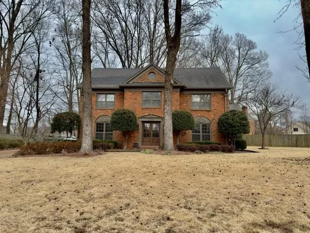 a front view of a house with a yard covered in snow