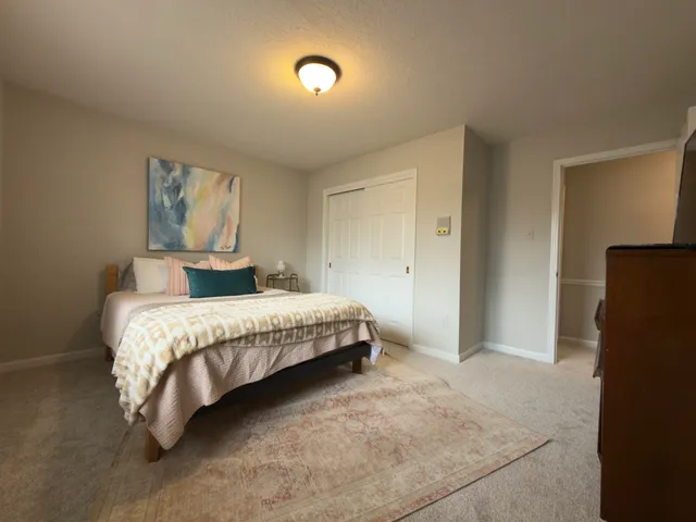 a bedroom with a bed and a painting on the wall