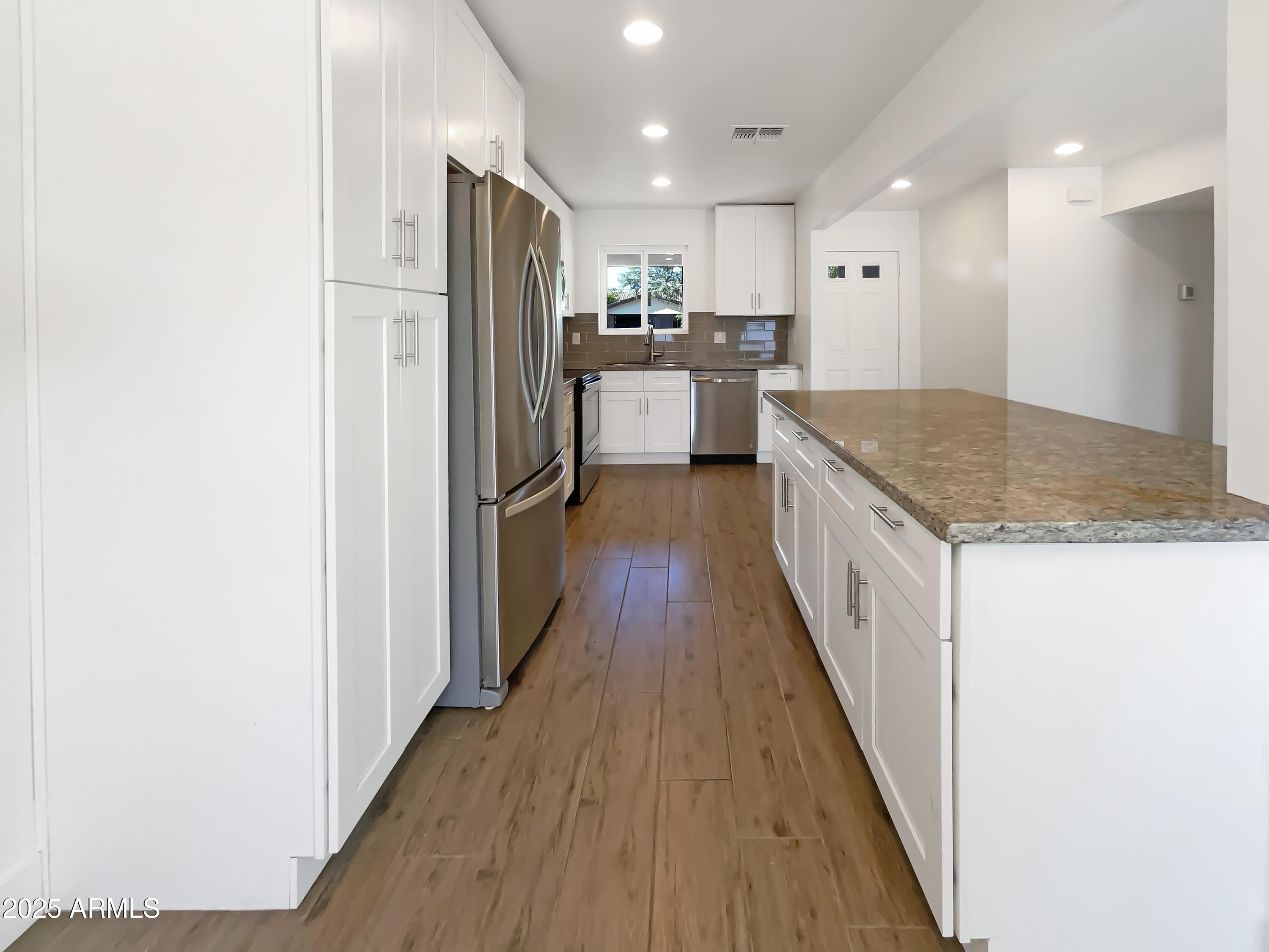 7231 North 23rd Avenue Phoenix, AZ 85021 - Photo 9 of 28 a kitchen with stainless steel appliances granite countertop a refrigerator and a sink