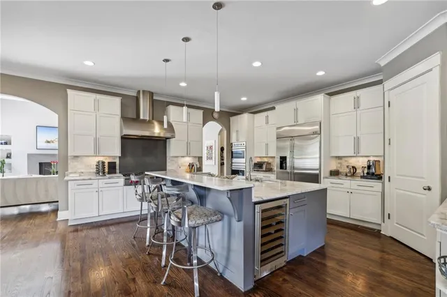 a kitchen with a sink a stove a refrigerator and white cabinets