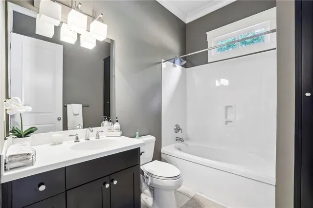 a bathroom with a double vanity sink toilet mirror and bathtub