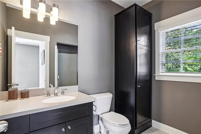 a bathroom with a sink a toilet a mirror and shower