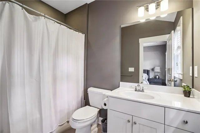 a bathroom with a sink a toilet and shower curtain
