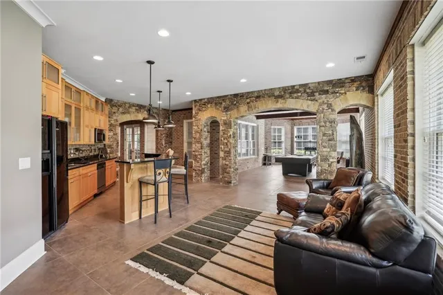 a living room with furniture kitchen view and a large window