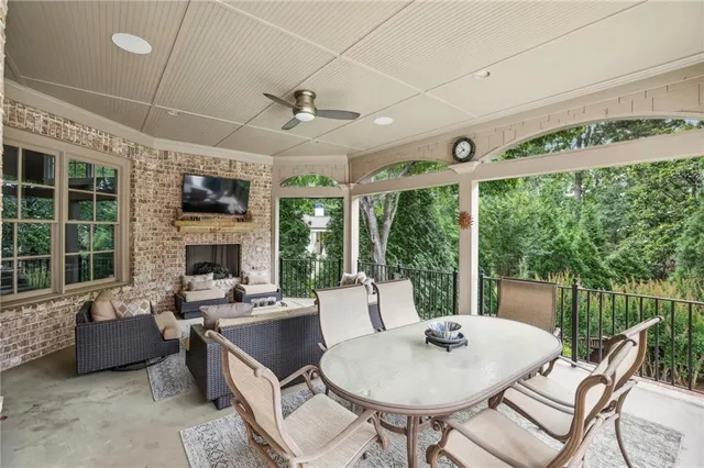 a living room with furniture a fireplace and a floor to ceiling window