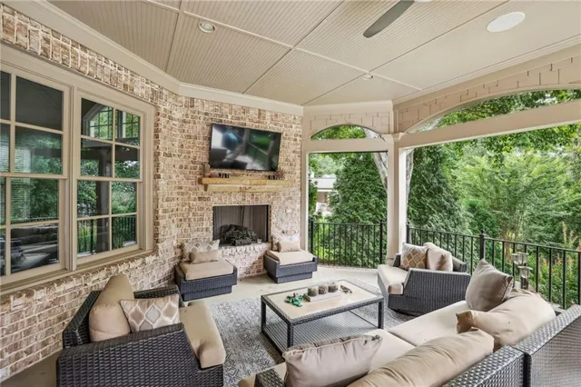 a living room with furniture a fireplace and a floor to ceiling window