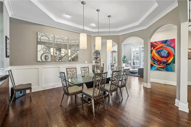 a view of a dining room with furniture a chandelier and wooden floor