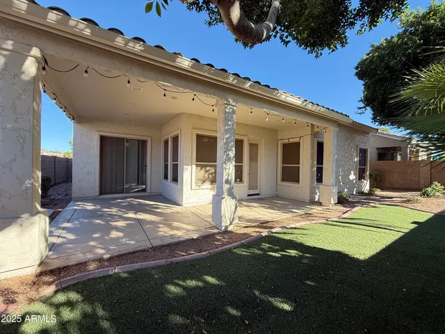 a view of a house with backyard and sitting area