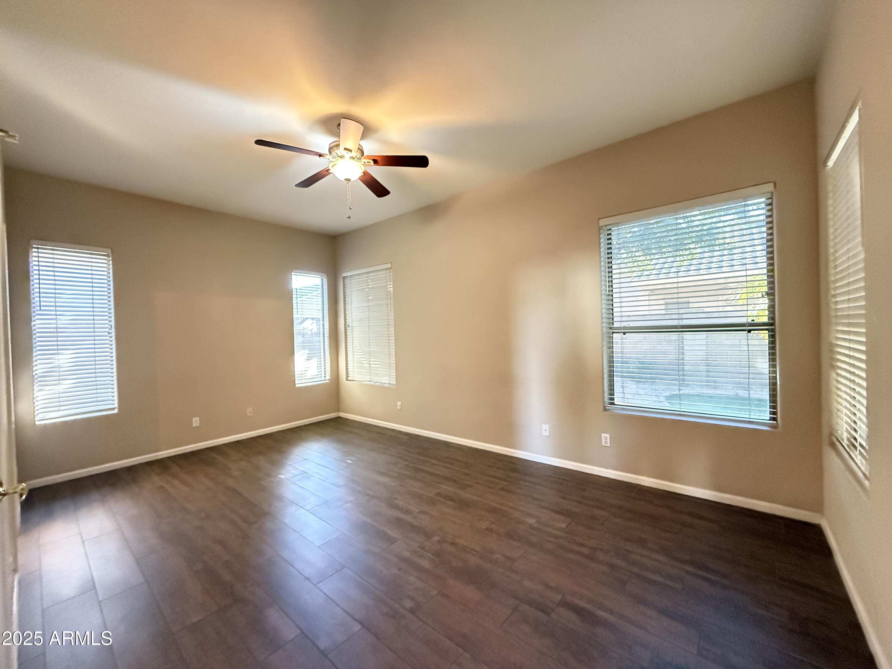 4805 East Wagoner Road Scottsdale, AZ 85254 - Photo 4 of 12 a view of an empty room with wooden floor and a window