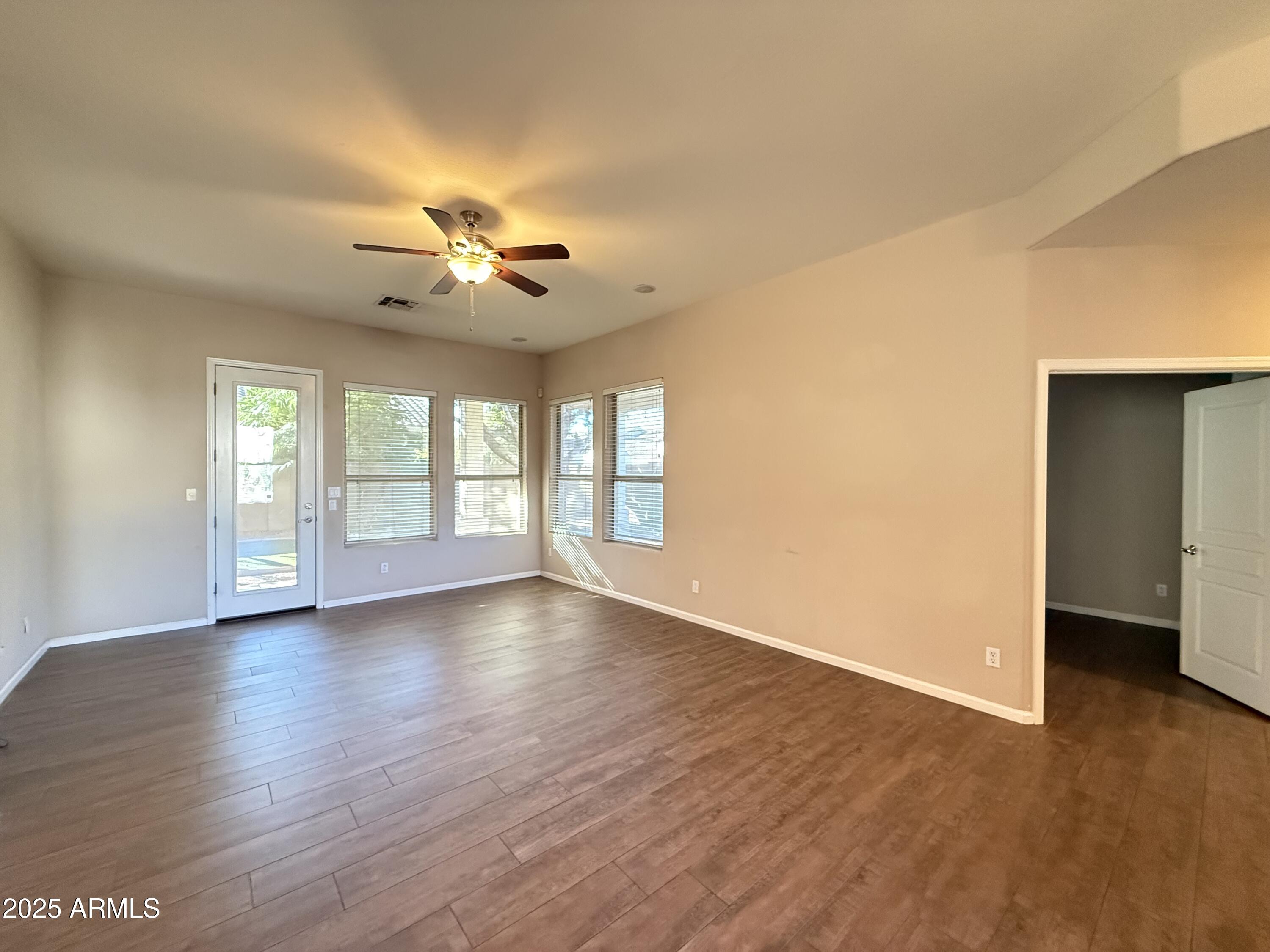 4805 East Wagoner Road Scottsdale, AZ 85254 - Photo 5 of 12 a view of an empty room with window and wooden floor