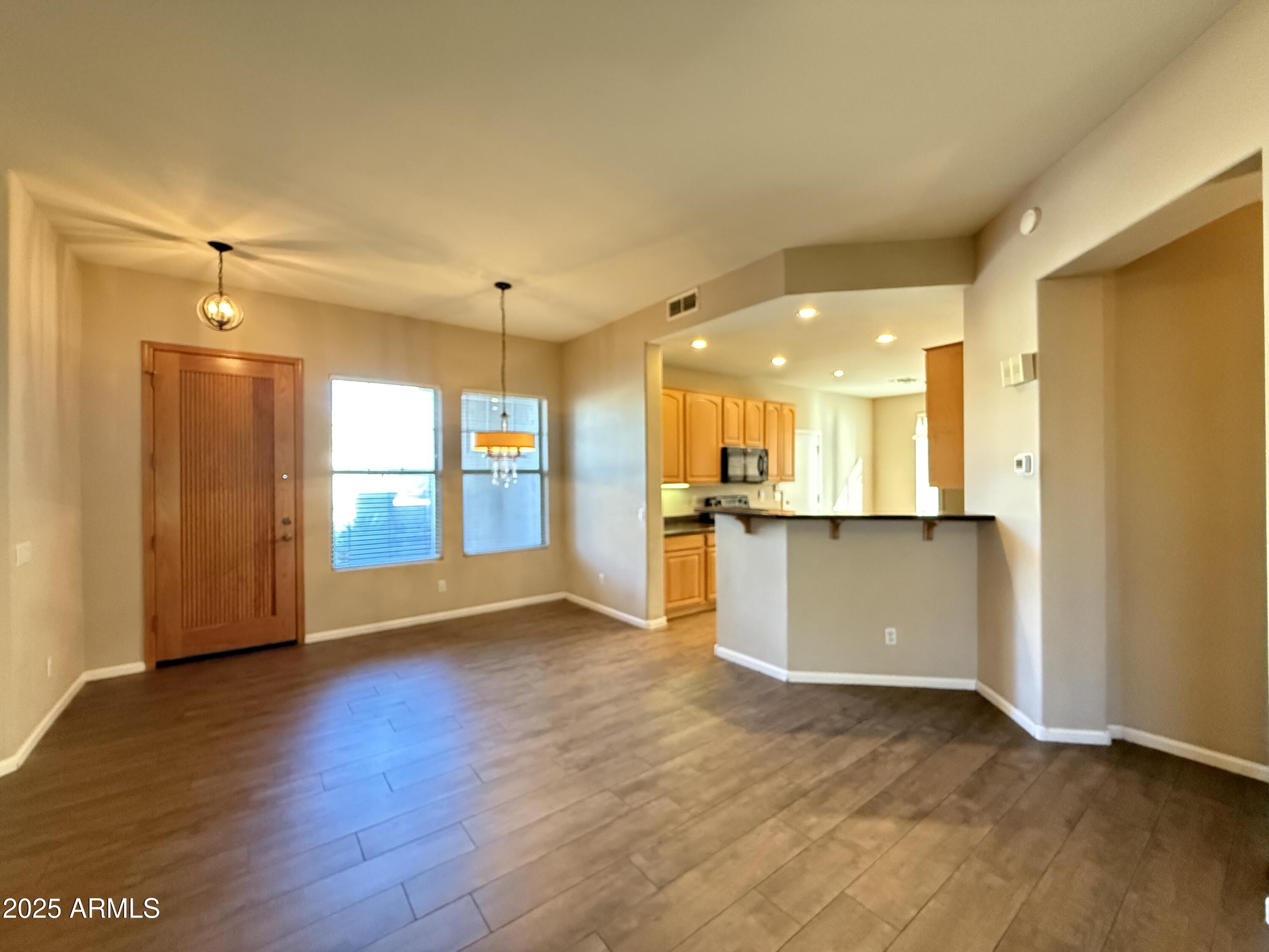 4805 East Wagoner Road Scottsdale, AZ 85254 - Photo 7 of 12 a view of an empty room and kitchen with wooden floor