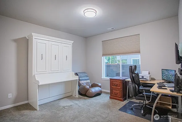 a bedroom with a bed and a computer on the desk