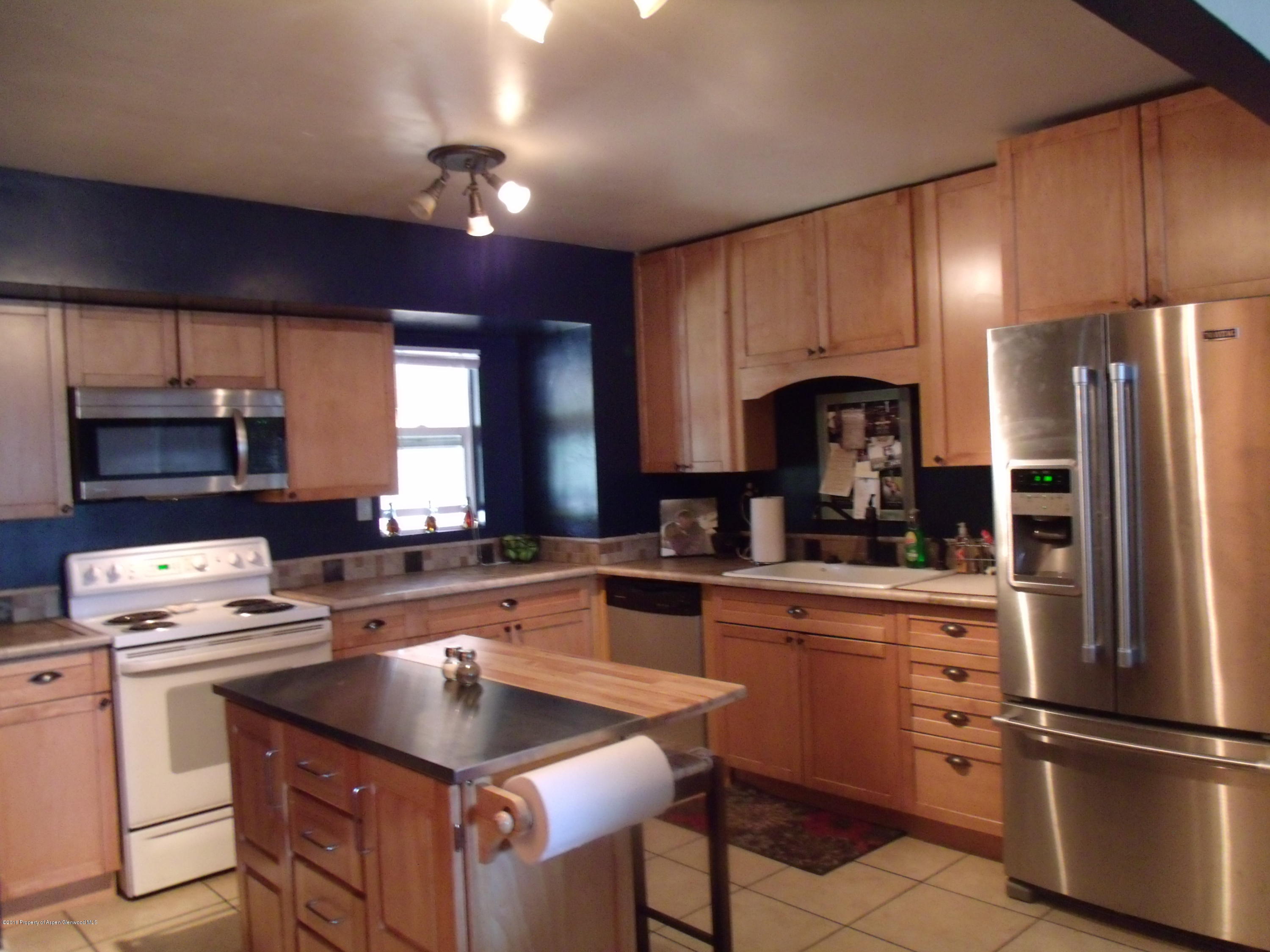 1202 West 5th Street Rifle, CO 81650 - Photo 6 of 14 a kitchen with cabinets stainless steel appliances and a window