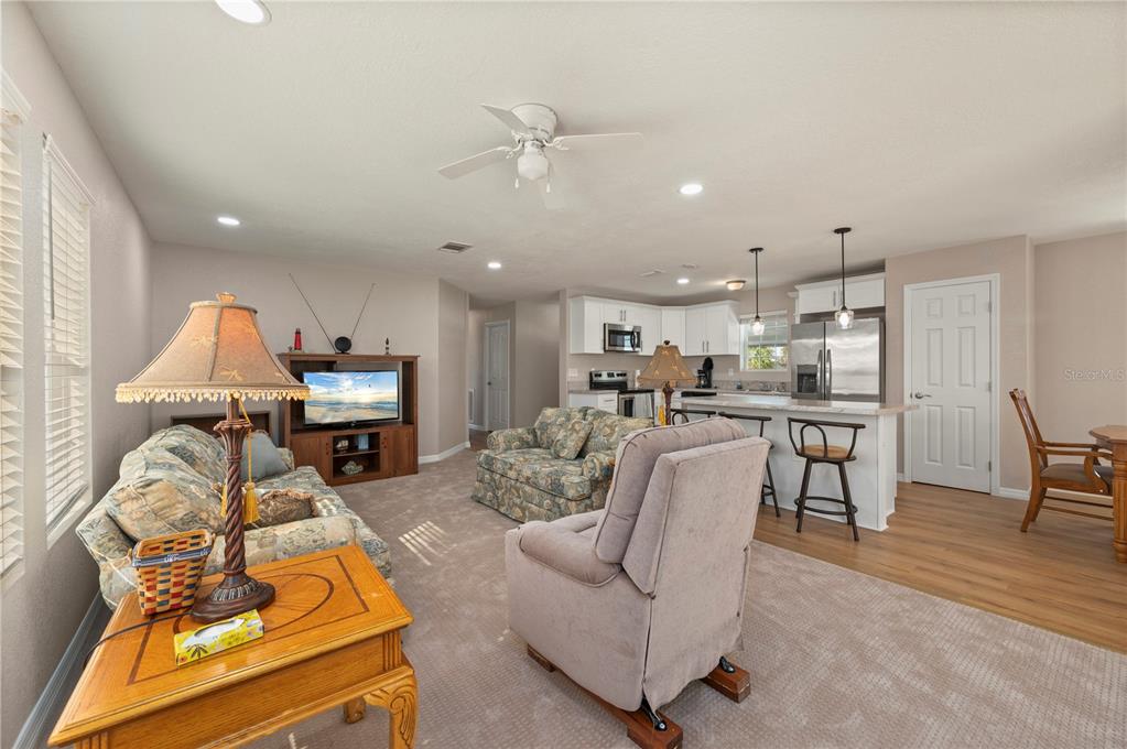 24437 Harbor View Road, Unit 51 Punta Gorda, FL 33980 - Photo 18 of 61 a living room with furniture kitchen view and a wooden floor