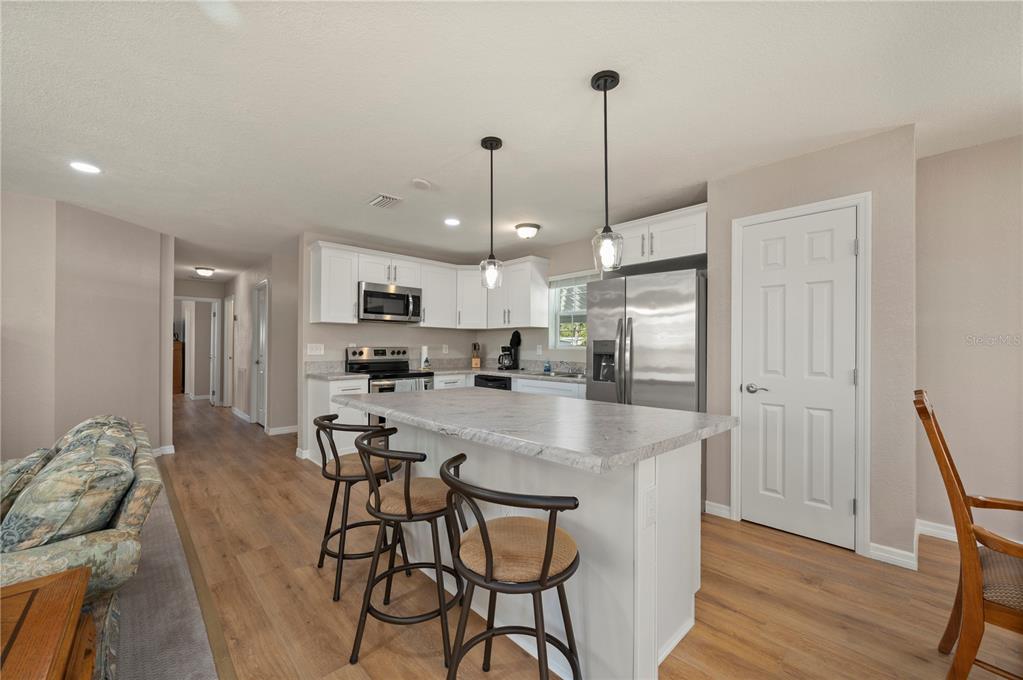 24437 Harbor View Road, Unit 51 Punta Gorda, FL 33980 - Photo 22 of 61 a kitchen with stainless steel appliances granite countertop a refrigerator a sink dishwasher a stove and white cabinets with wooden floor