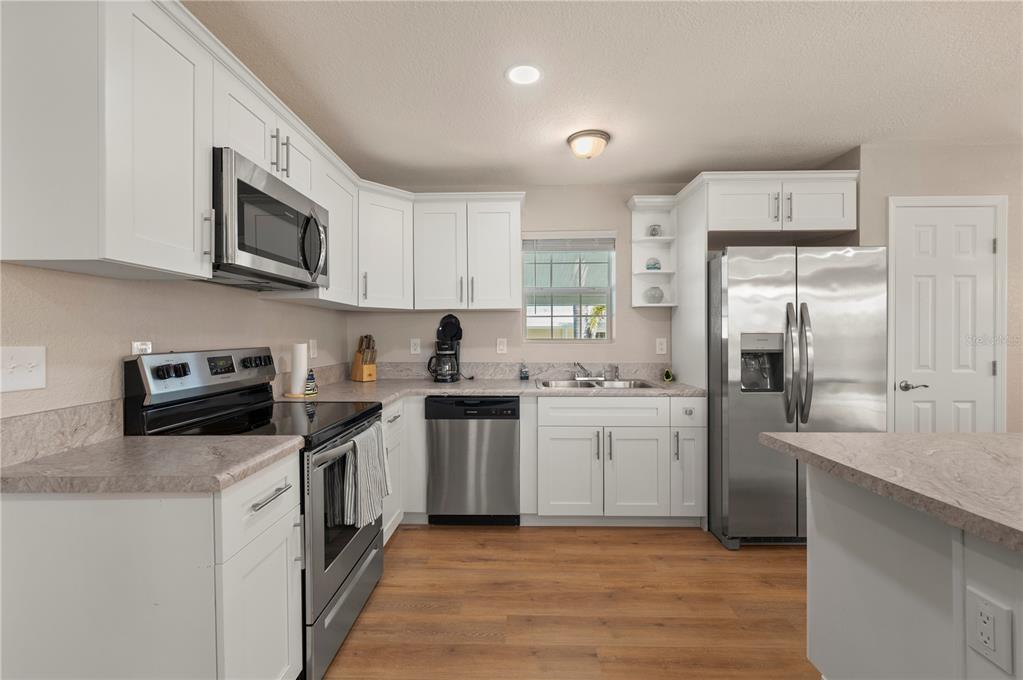 24437 Harbor View Road, Unit 51 Punta Gorda, FL 33980 - Photo 26 of 61 a kitchen with stainless steel appliances a stove sink microwave and cabinets