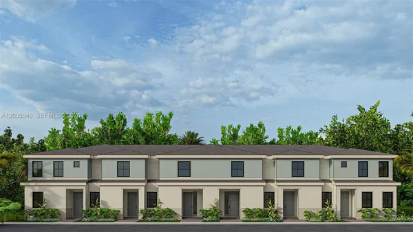 a front view of a residential apartment building with a yard and wooden fence