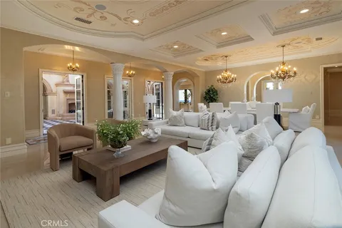 a living room with furniture and chandelier