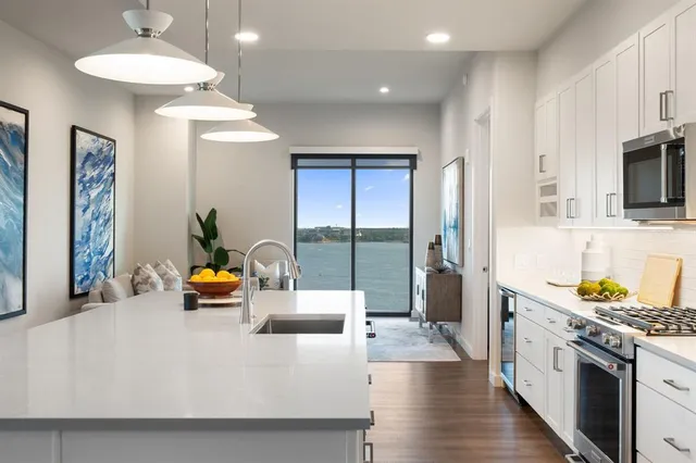 a kitchen with stainless steel appliances granite countertop a sink and a refrigerator