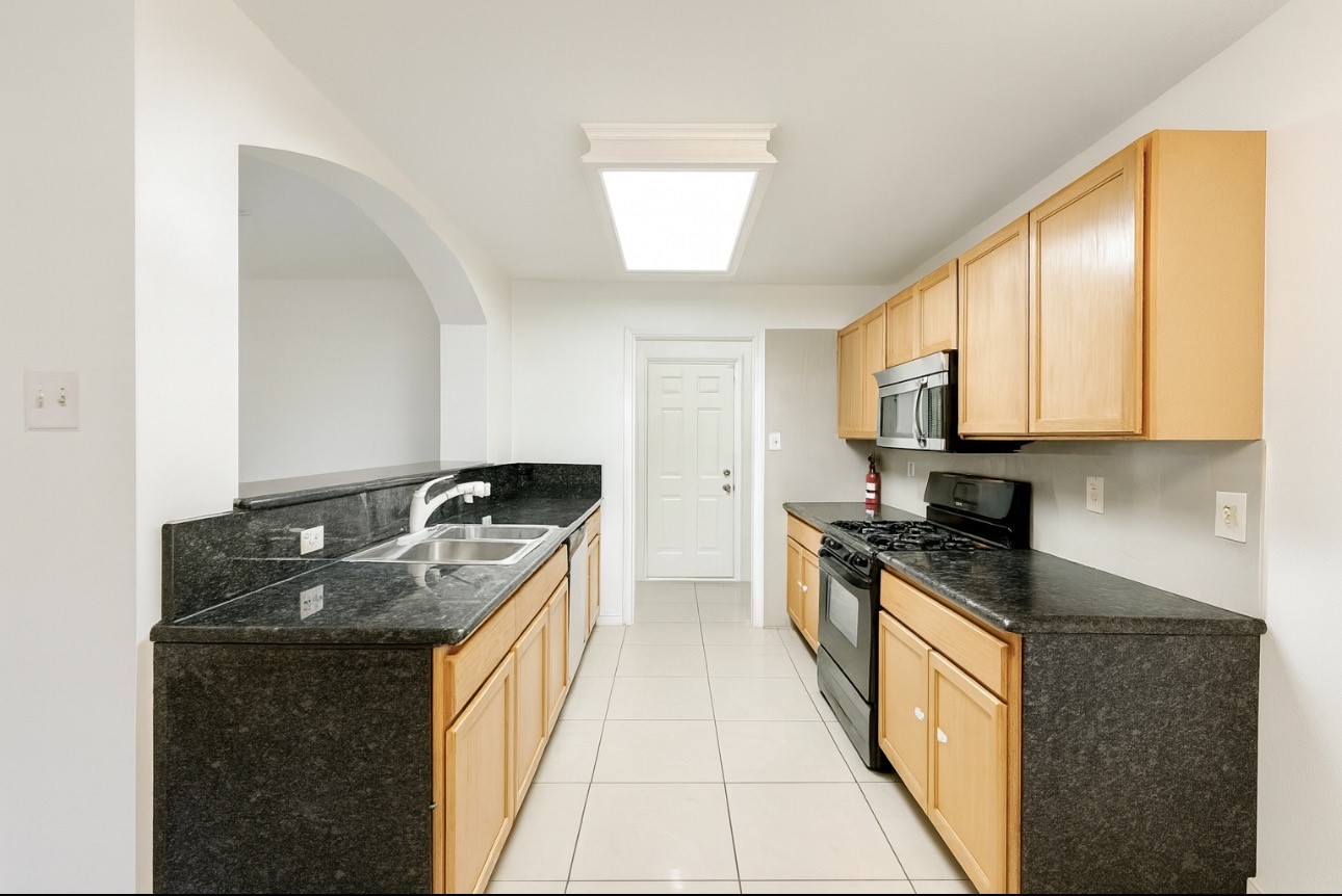9811 Mango Street Houston, TX 77075 - Photo 6 of 14 a kitchen with stainless steel appliances granite countertop a stove a sink and a microwave
