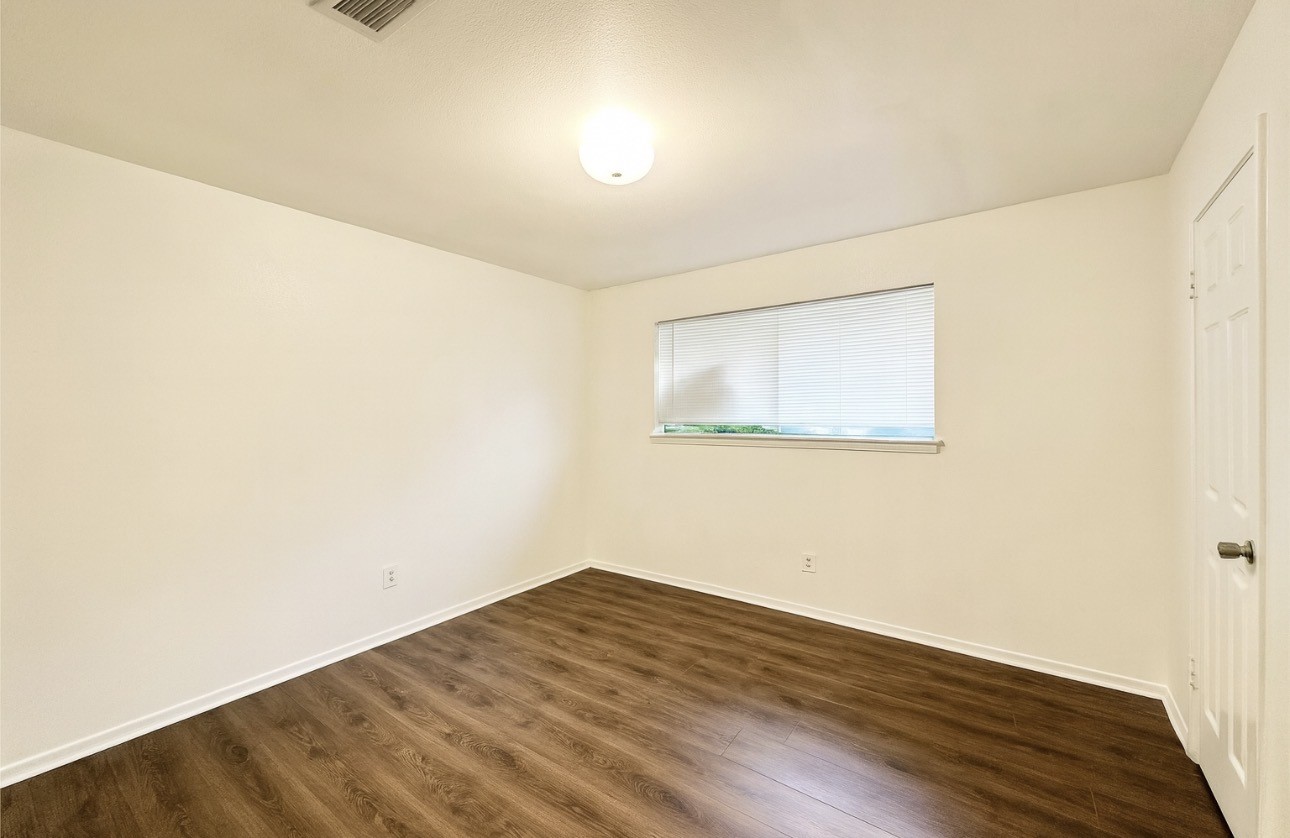 9811 Mango Street Houston, TX 77075 - Photo 10 of 14 an empty room with wooden floor and windows